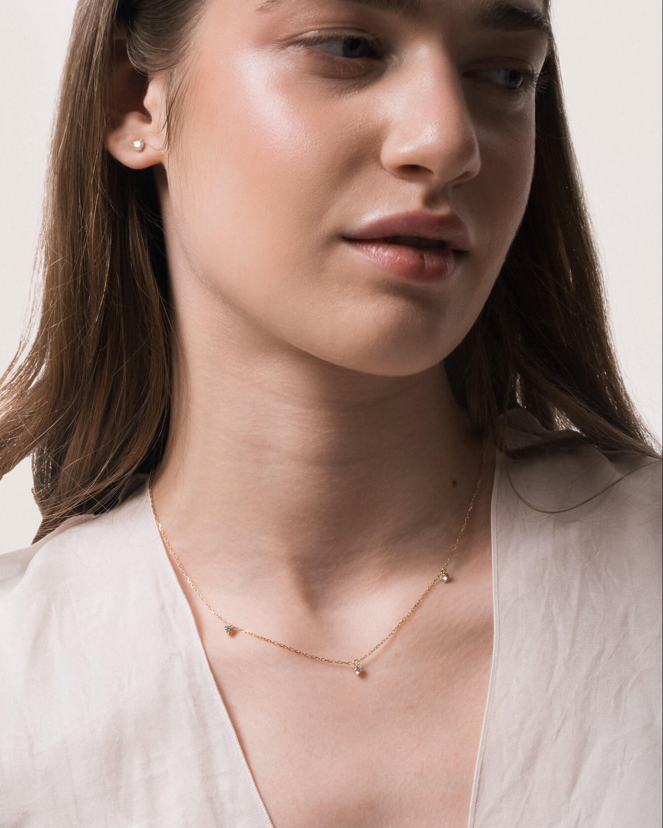 Model wearing the Elio three diamond necklace in solid yellow gold by Anate, worn on neck
